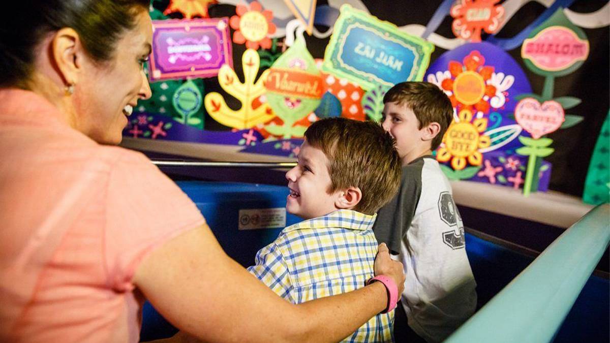 Mom and Sons riding It’s a Small World at Disneyland - Los Angeles, California, USA